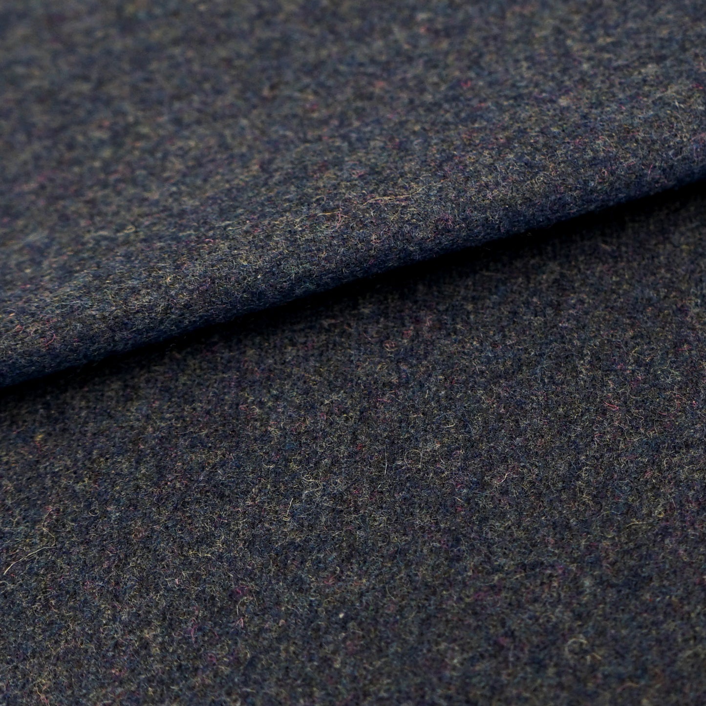 Dark blue wool fabric with a plain texture; close-up fold shows woven texture.