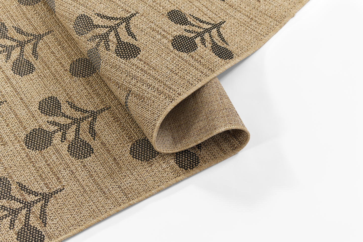 Natural jute rug with dark brown olive branch print, rolled corner, rustic coastal-inspired home decor.