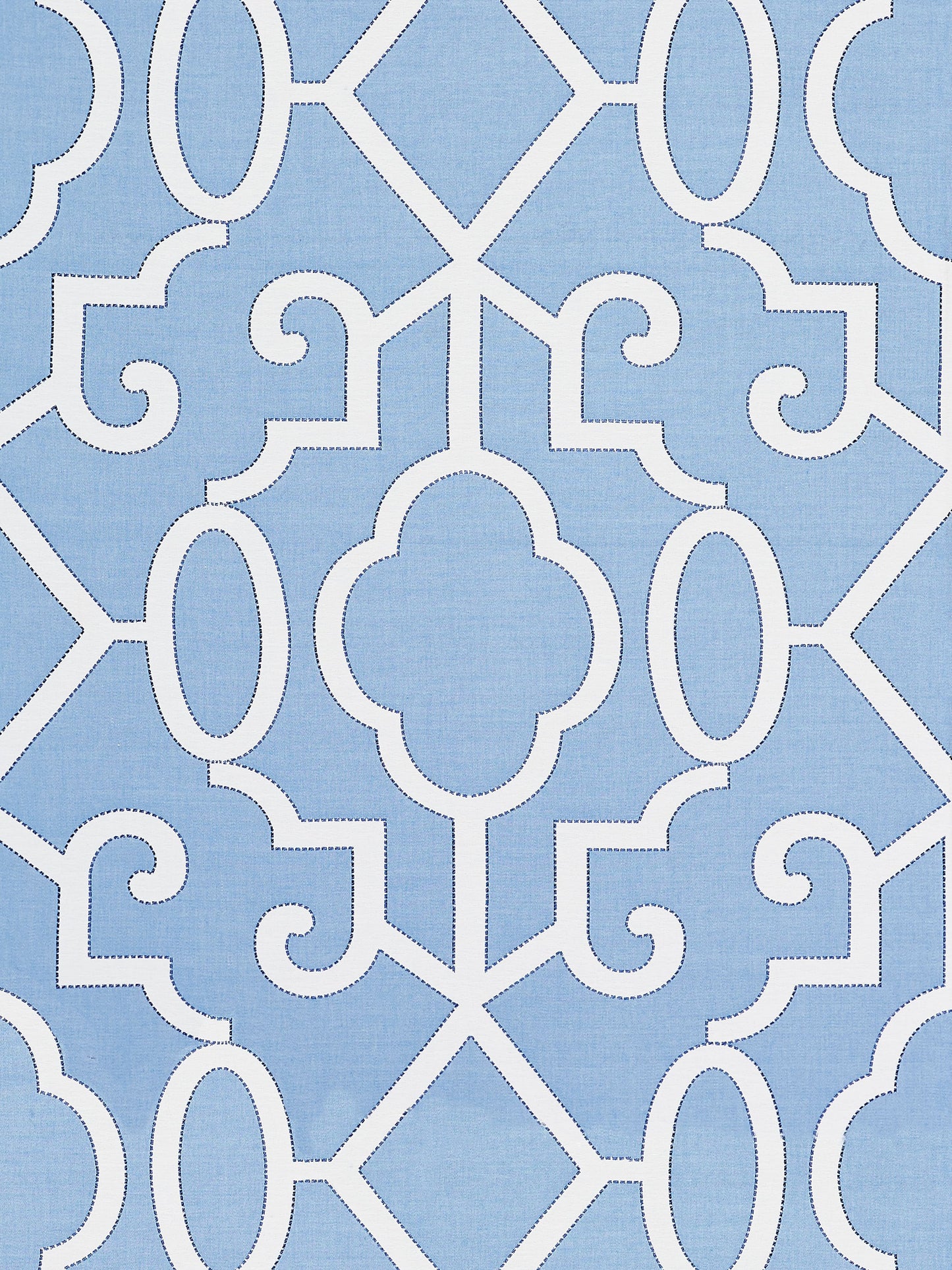 Blue fabric with white lattice and quatrefoil motifs; Moroccan-inspired geometric tile pattern.