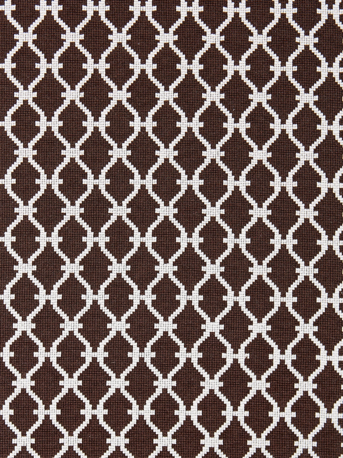 Dark espresso-brown woven fabric with white interlocking lattice/trellis pattern; upholstery textile.