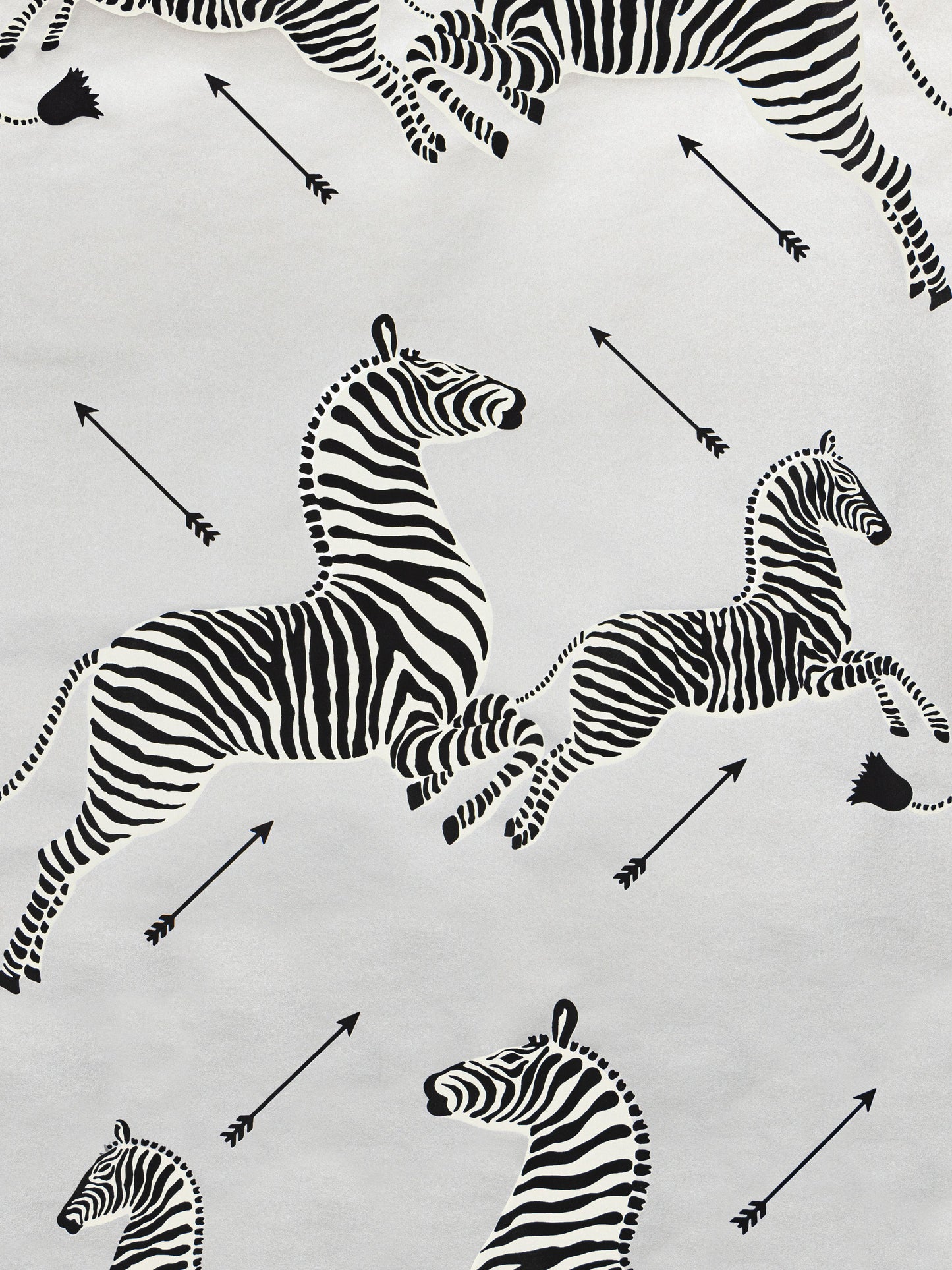 White fabric with black zebra silhouettes and arrows; safari-inspired textile for clothing, crafts, or decor.