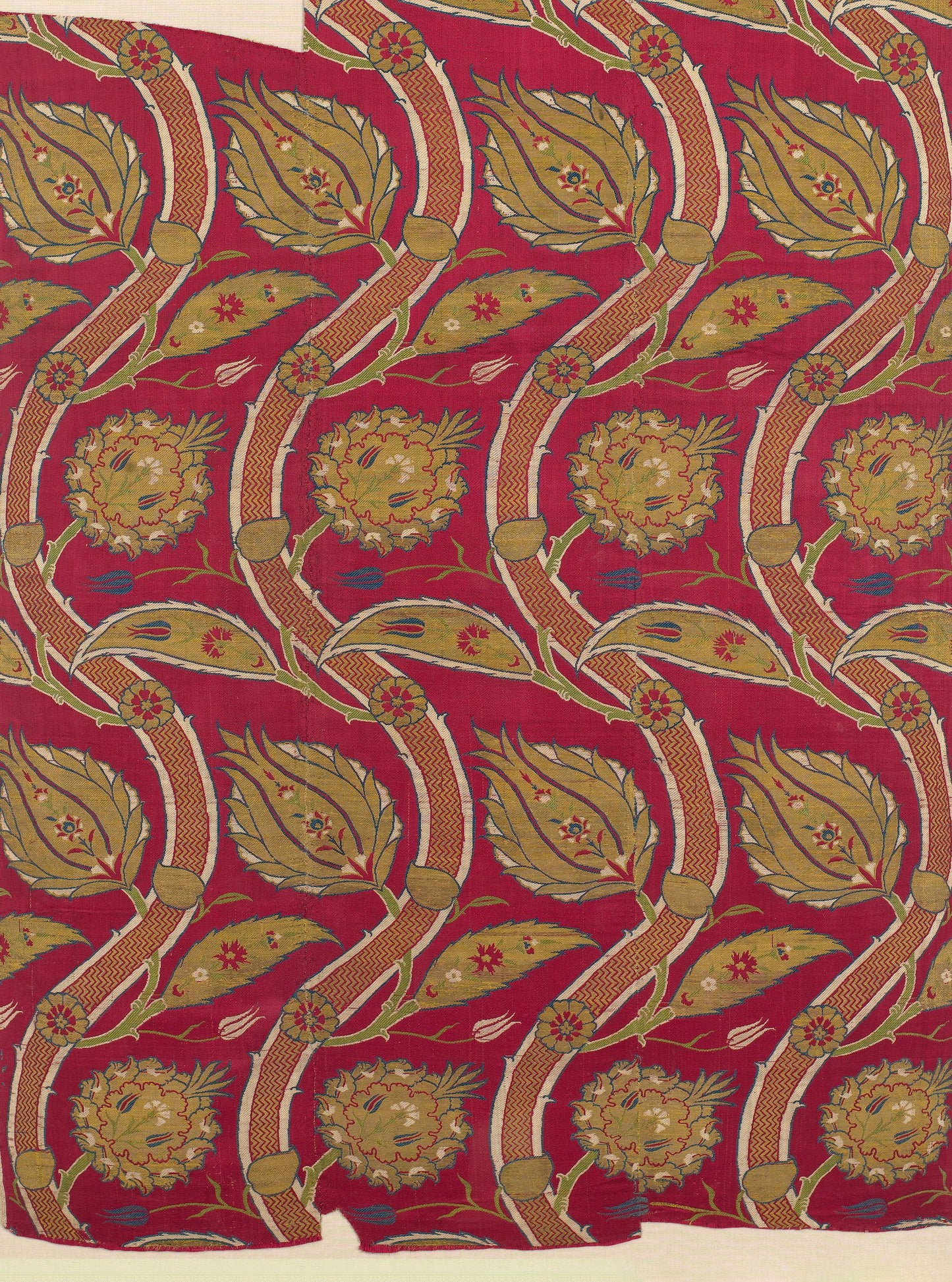 Rich red fabric with repeating gold botanical pattern of curved stems, leaves, and large stylized flowers.
