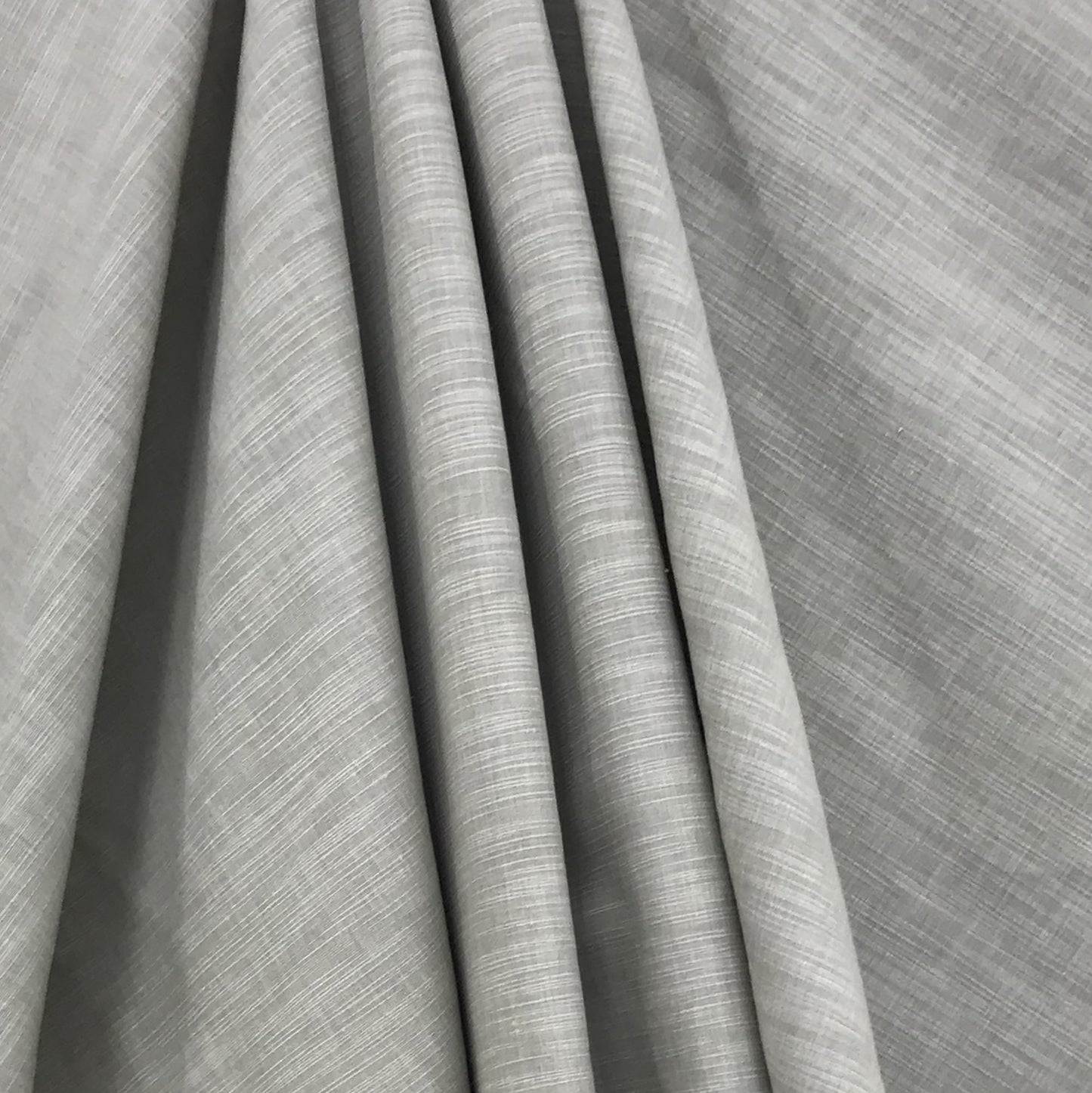 Green shantung fabric draped in folds, showcasing subtle weave and soft, elegant texture; faux silk finish.