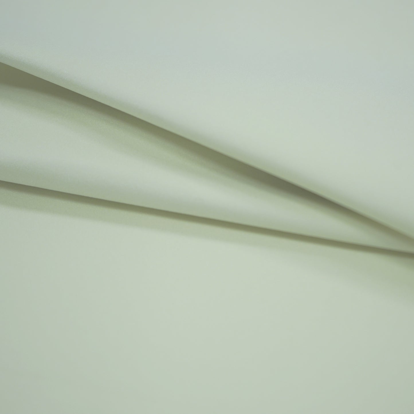 Offwhite fabric with soft diagonal folds and a smooth surface.