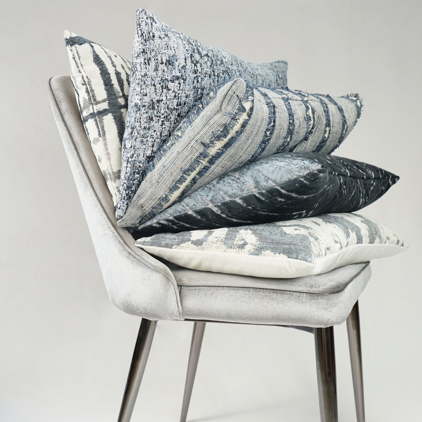 Slate-blue fringe pillow, textured with global stripes, 24 x 24 inches.