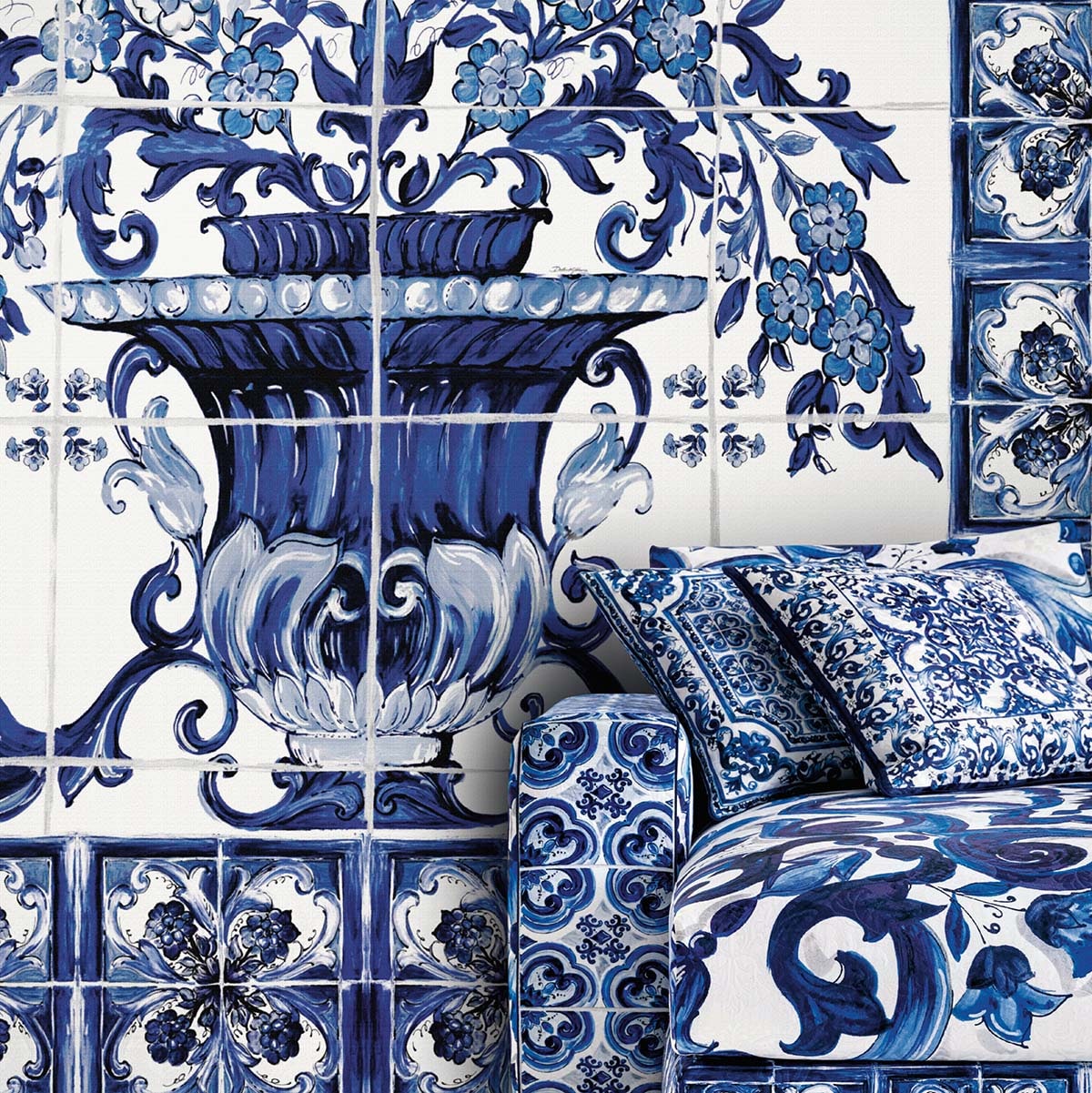 Blue-and-white ceramic tile wall with ornate vase and floral patterns, matching blue patterned cushions on a sofa.