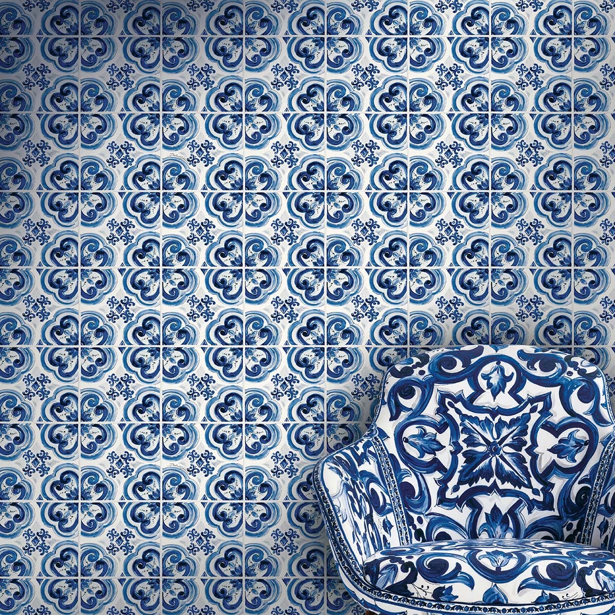 Blue and white azulejo tile wall pattern with ornate motifs; curved chair upholstered in matching tile-inspired fabric.