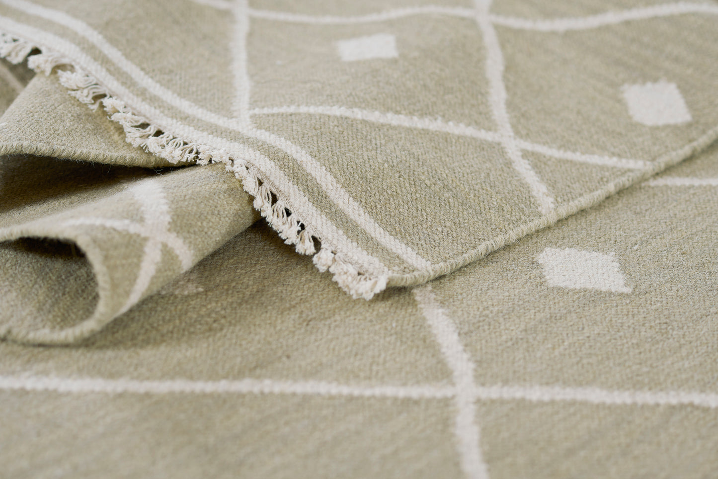 Beige woven rug with white diamond grid pattern and fringe, 9' x 12'.