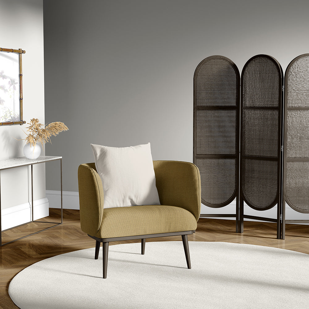 Camel geometric textured upholstery fabric; visible in a room setting on furniture with a circular cream rug and woven folding screens in the background.