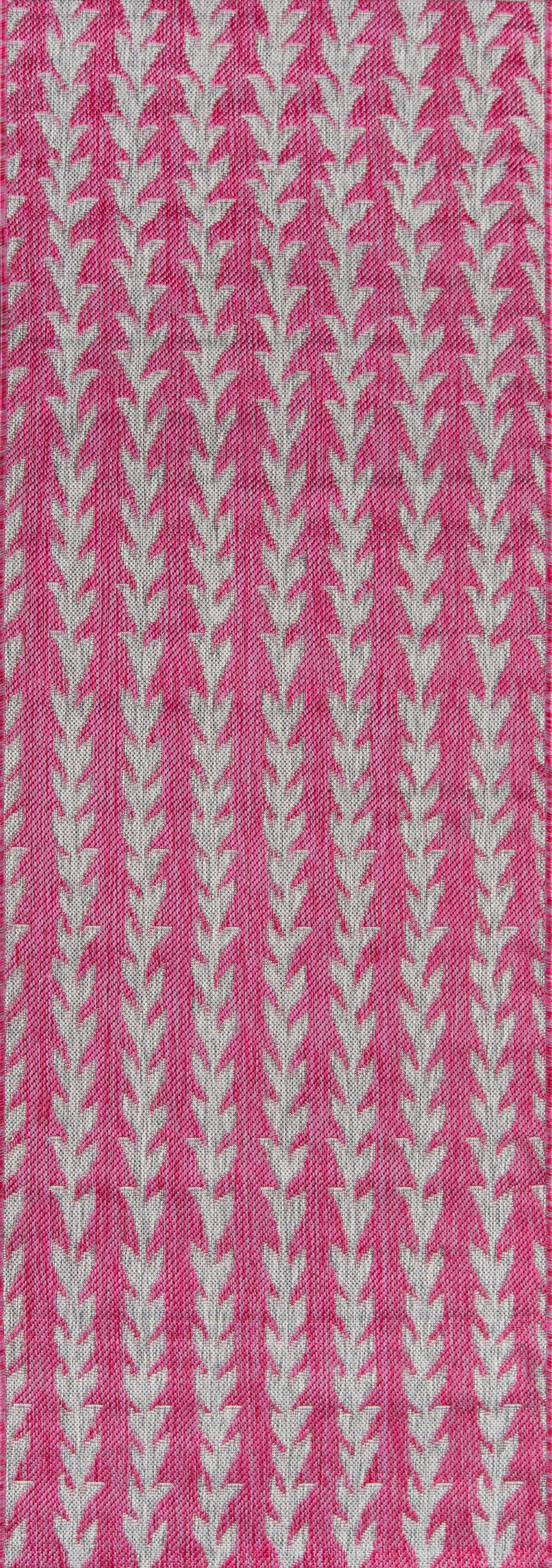 Pink woven rug runner with vertical white chevron/leaf stripes in a repeating pattern.