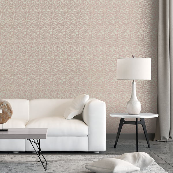 Minimalist living room with white sofa, round side table and ceramic lamp; rose gold metallic geometric wallpaper and gray curtains.