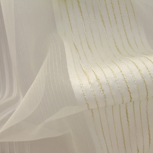Sheer white voile with subtle pinstripes beside cream textured fabric with pale yellow vertical ridges.