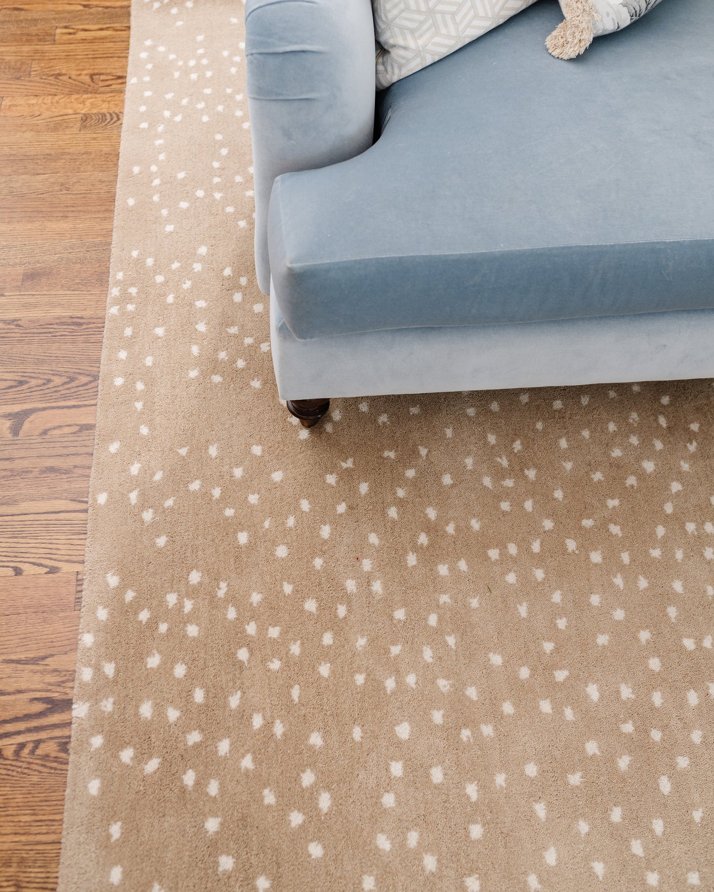 Beige speckled rug on wood floor, 10' x 14'.