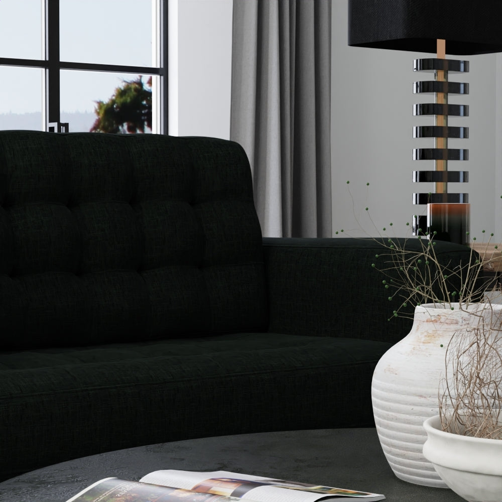 Modern living room: charcoal solid fabric sofa, round coffee table, white ceramic vase with dried branches, curtains, striped lamp.