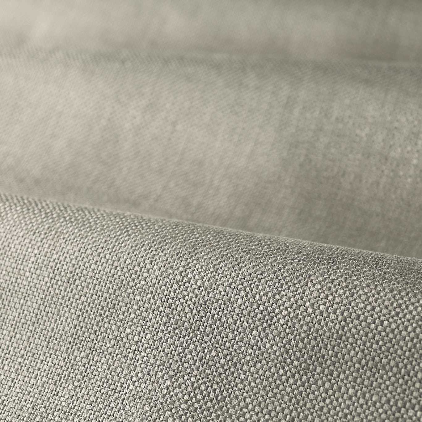 Close-up of light gray woven fabric with fine texture and soft drape.