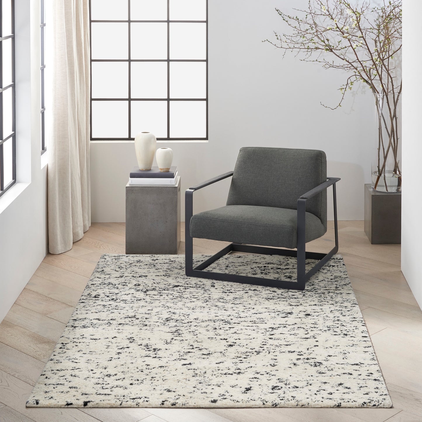 Gray textured rug with cream and gray tones in a bright minimalist living room.