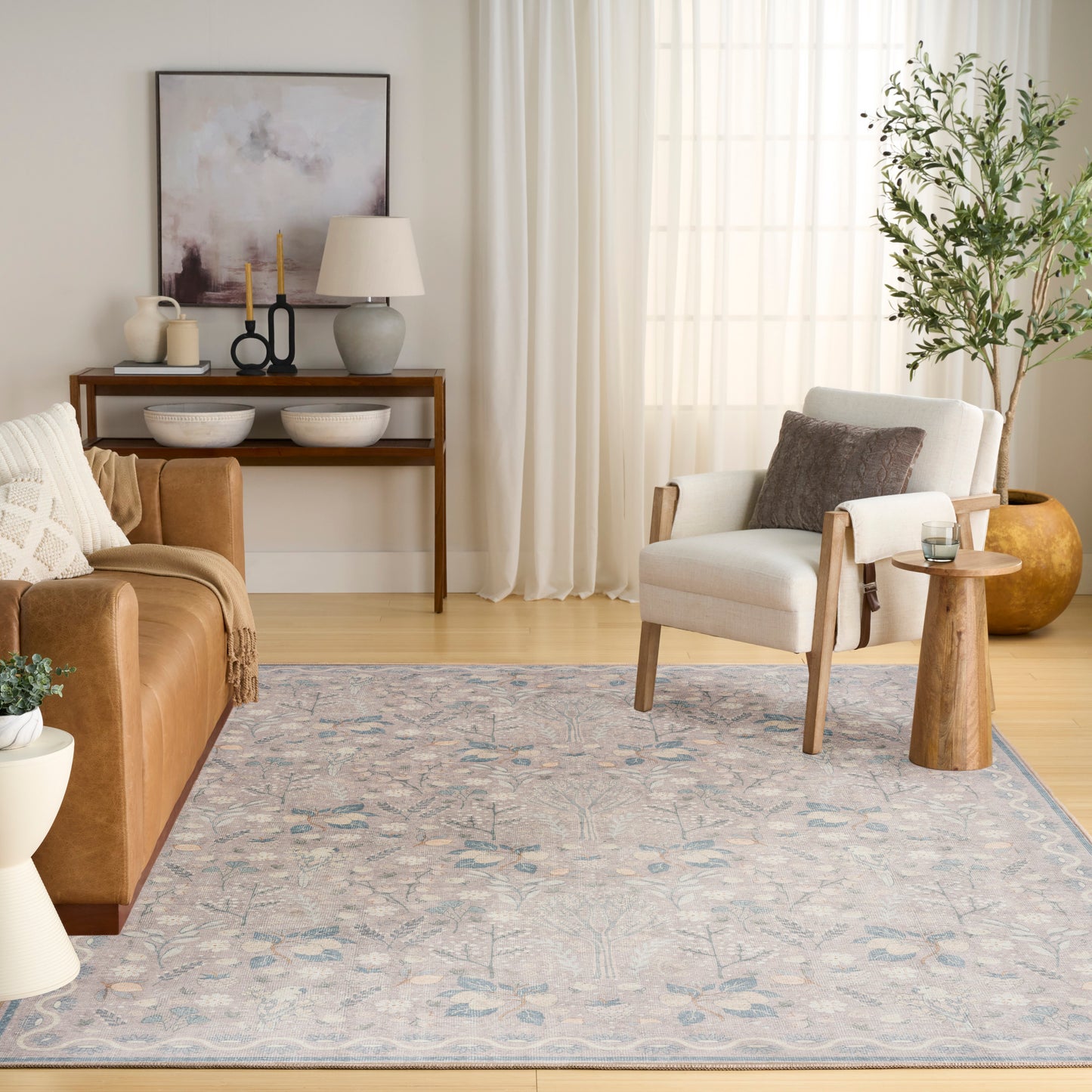 Light blue and ivory woven area rug with subtle floral/abstract pattern, in a modern cozy living room.