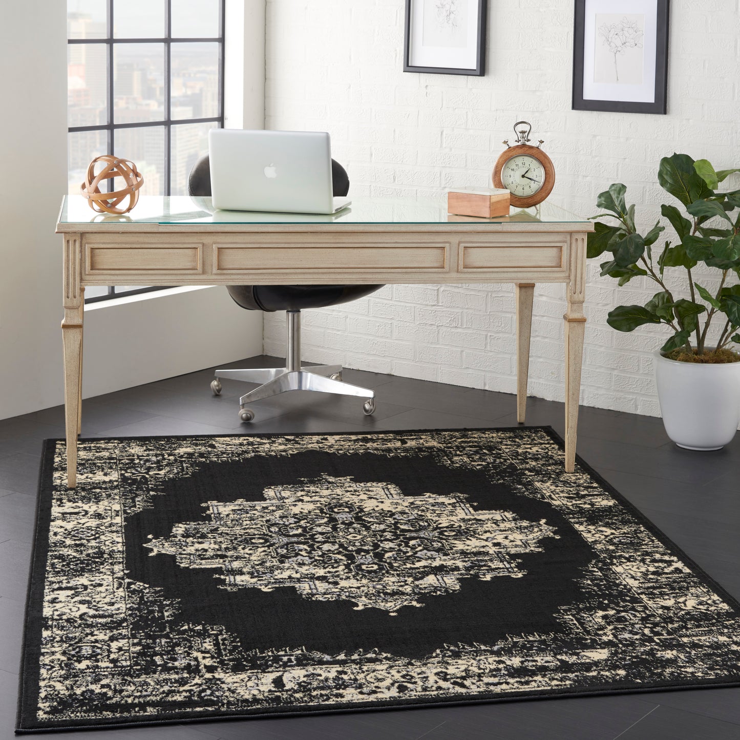 Vintage 4' x 6' rug with ornate black & cream pattern.