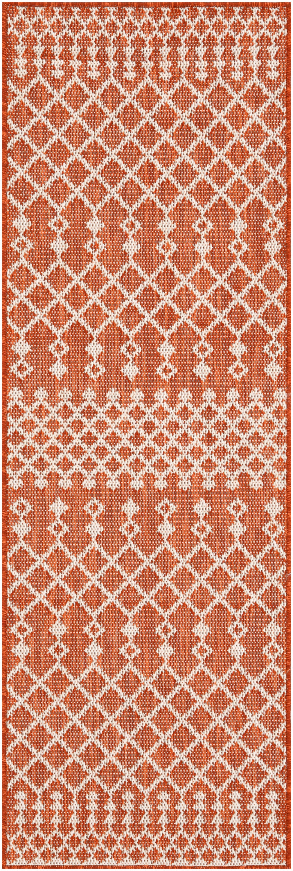 Long rust-orange and white woven rug runner with a repeating diamond lattice pattern and fringe ends.