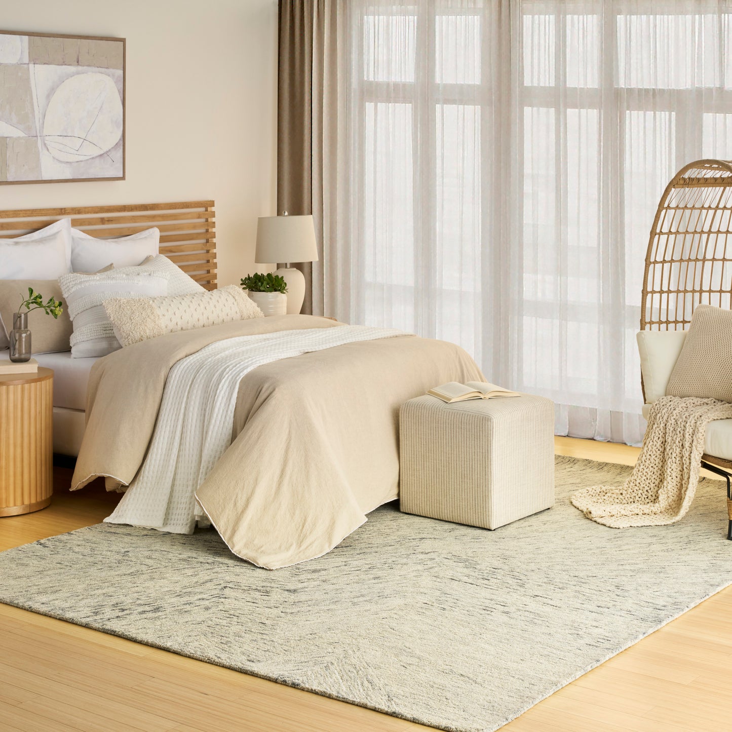 Neutral beige textured rug on a light wood floor in a bright room.