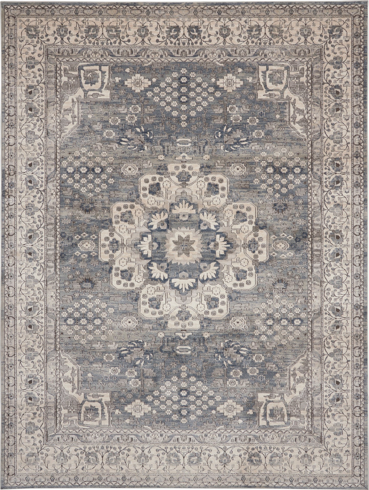 Blue-gray oriental rug with ivory central medallion, intricate floral border; distressed vintage look for living room decor.