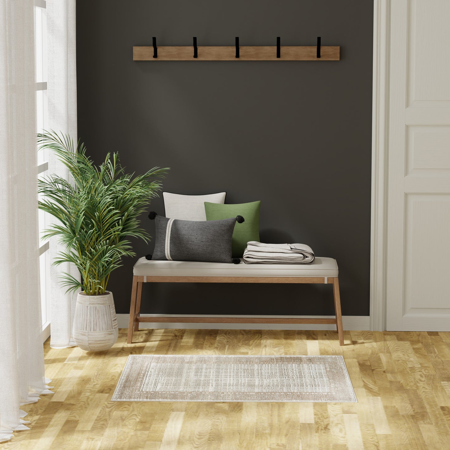 Modern beige woven rug (2' x 4') with a wooden entry bench featuring a white cushion and green/gray pillows, a coat rack, plant, and dark wall in the background.