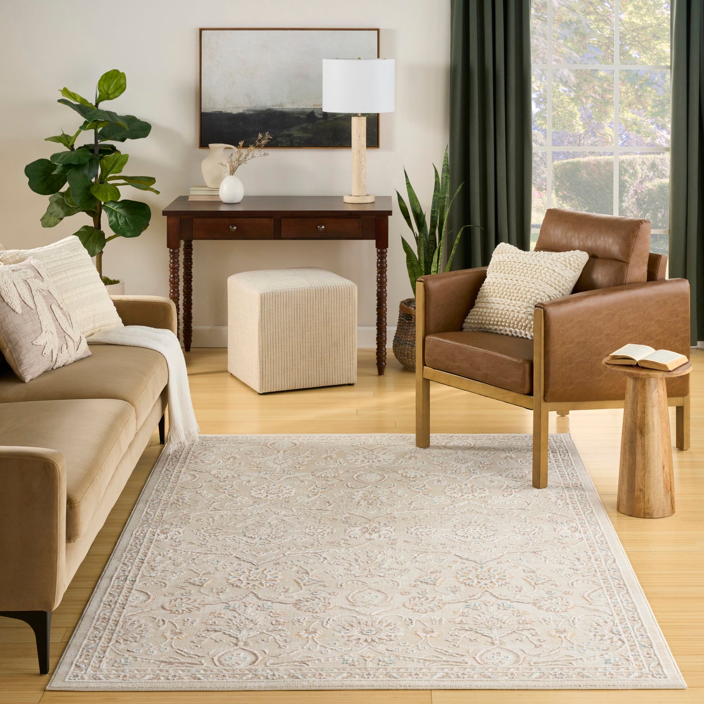 Cozy mid-century living room with a beige sofa, brown leather chair, wooden console, neutral patterned rug and greenery.