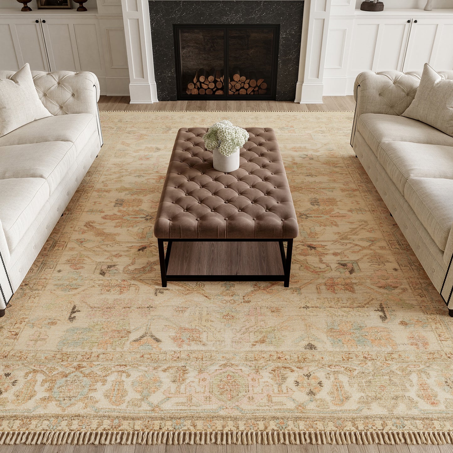 Brown tufted leather ottoman with black metal frame on a beige patterned rug between cream sofas.