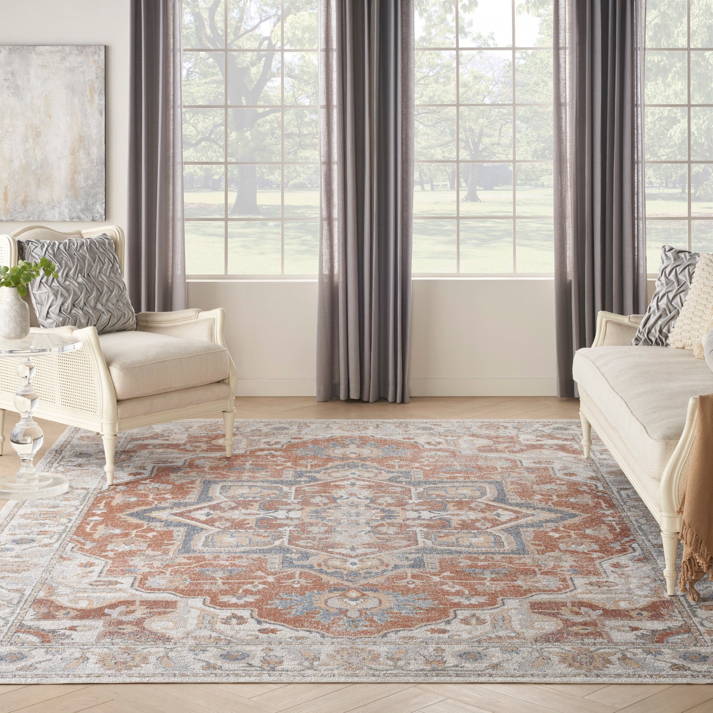 Neutral living room with cream sofas, gray curtains, and a traditional oriental rug in rust, blue, and ivory.