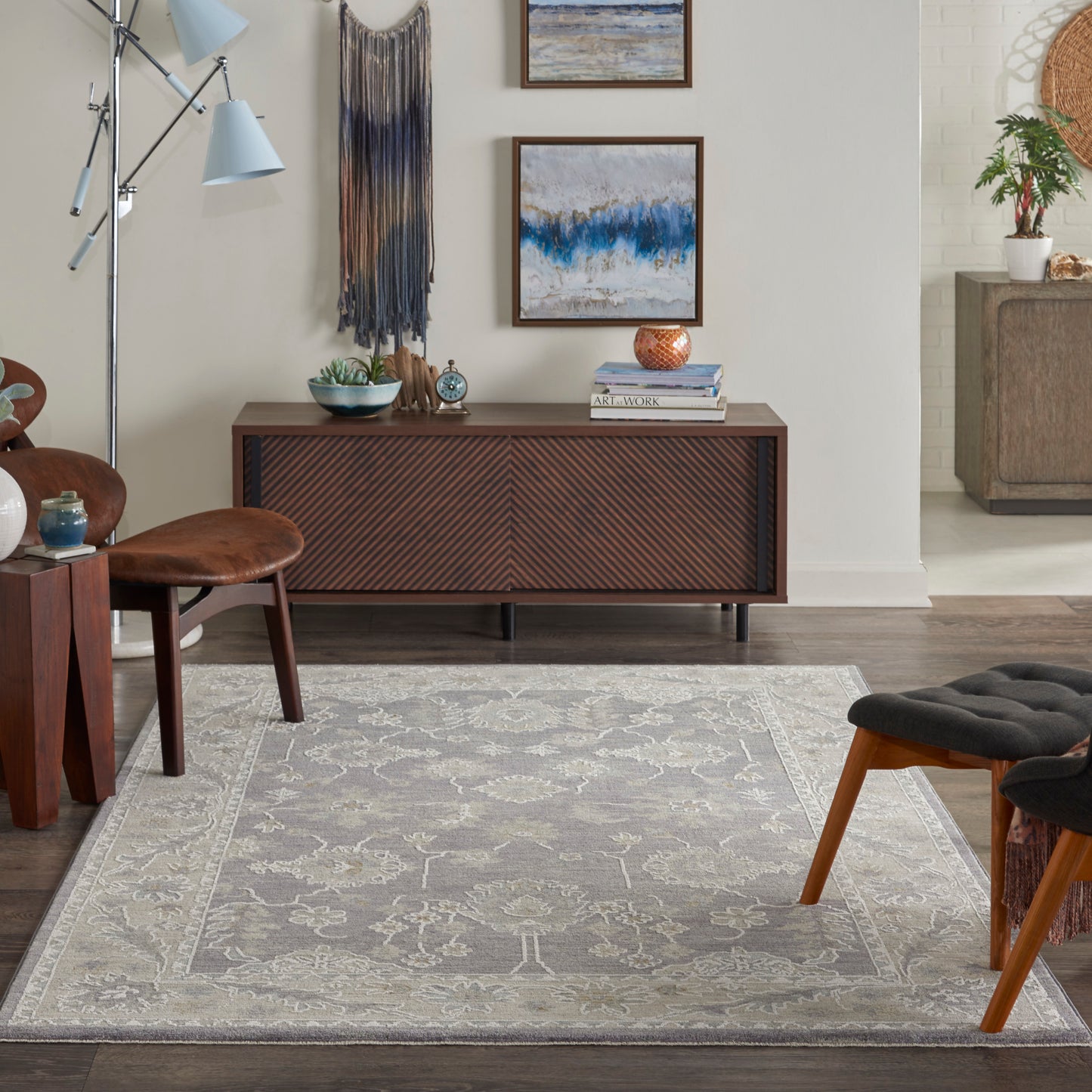 Grey patterned area rug with a light beige border on a wood floor in a mid-century modern living room setting.