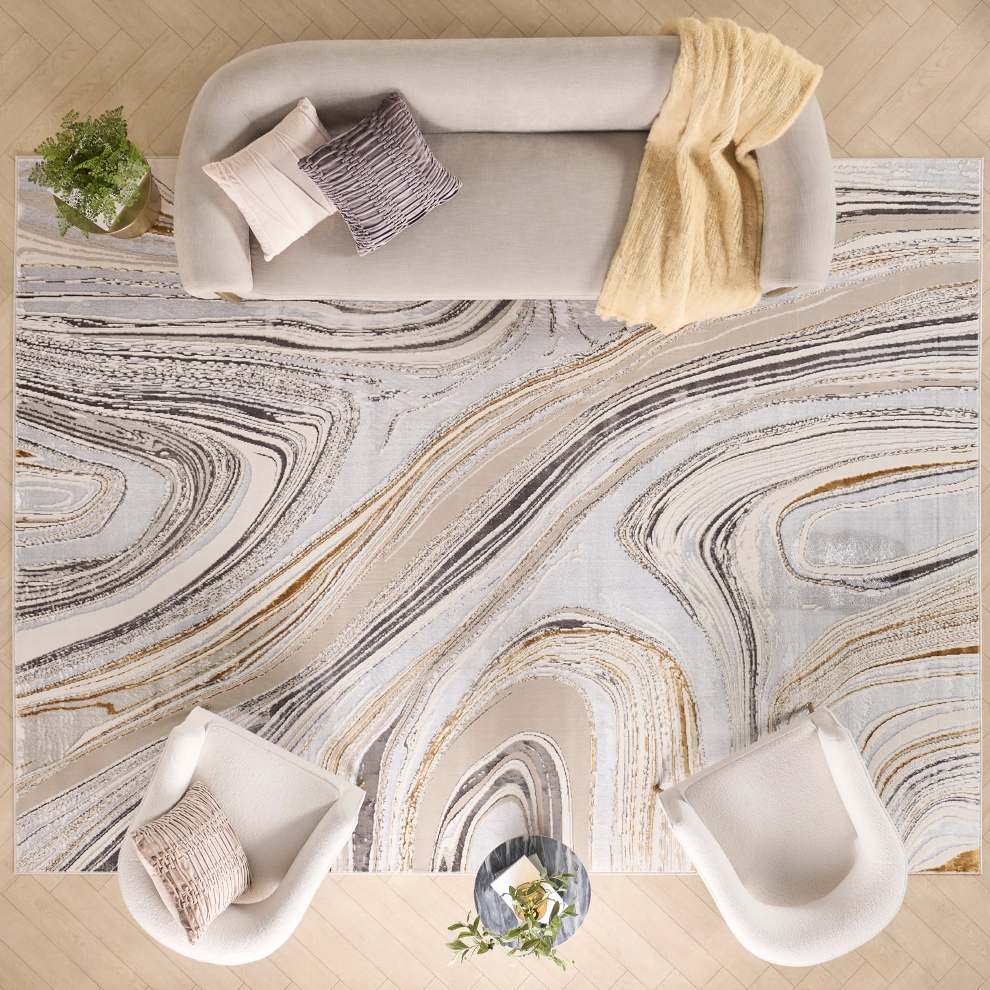 Neutral marble-pattern area rug with beige, gray and black swirls; modern living room with pale sofa and white chairs.