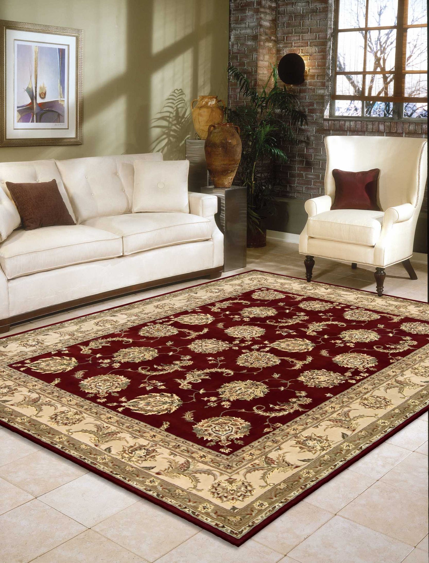 Ornate burgundy area rug with gold floral motifs and beige border in a cream living room with sofa and armchair.