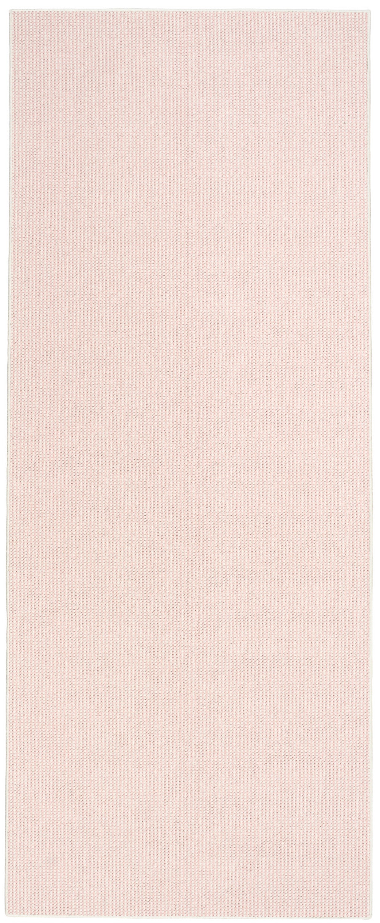 Pink rectangular runner rug with tiny dot texture and white border.