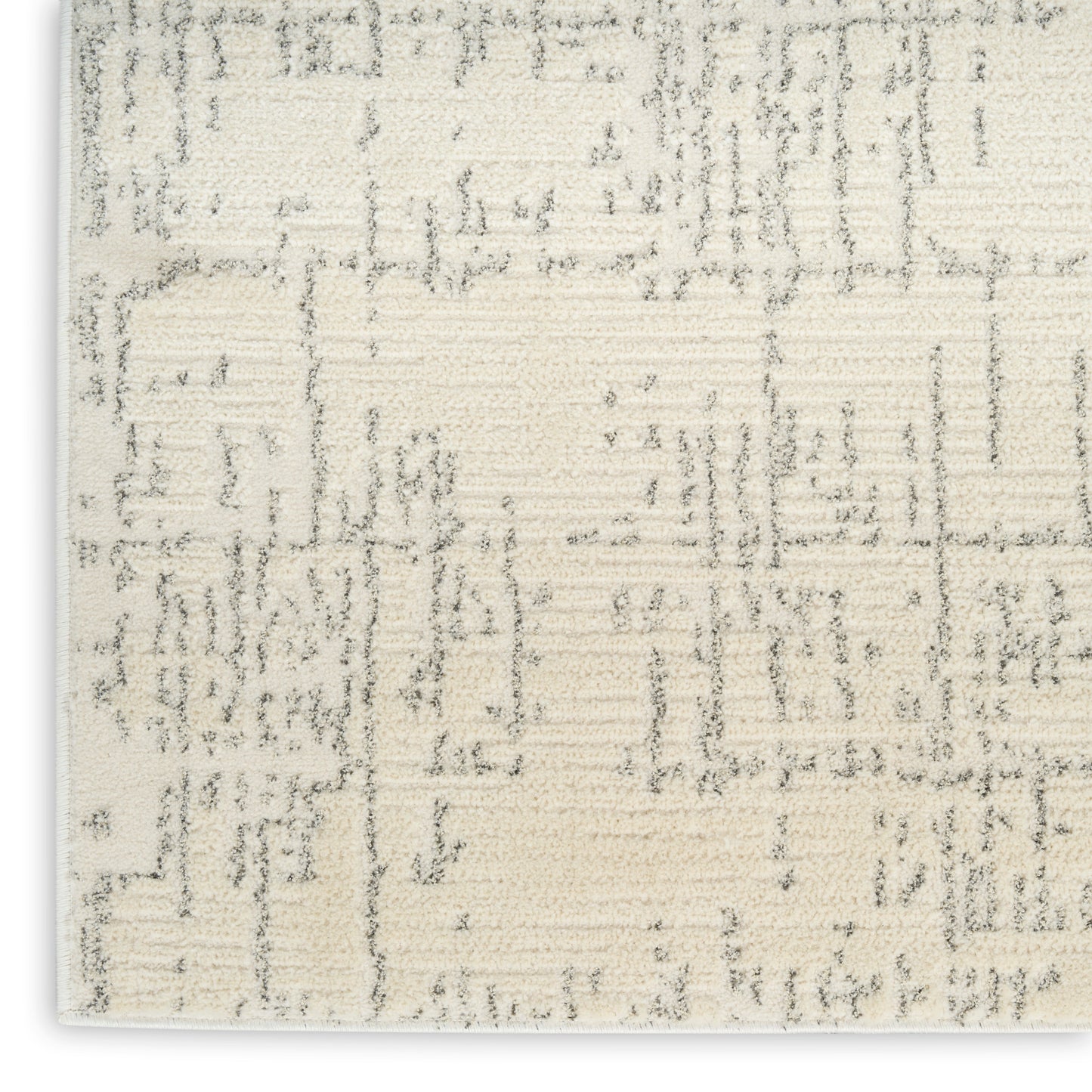 Cream flat-weave rug with subtle gray geometric pattern and textured surface.