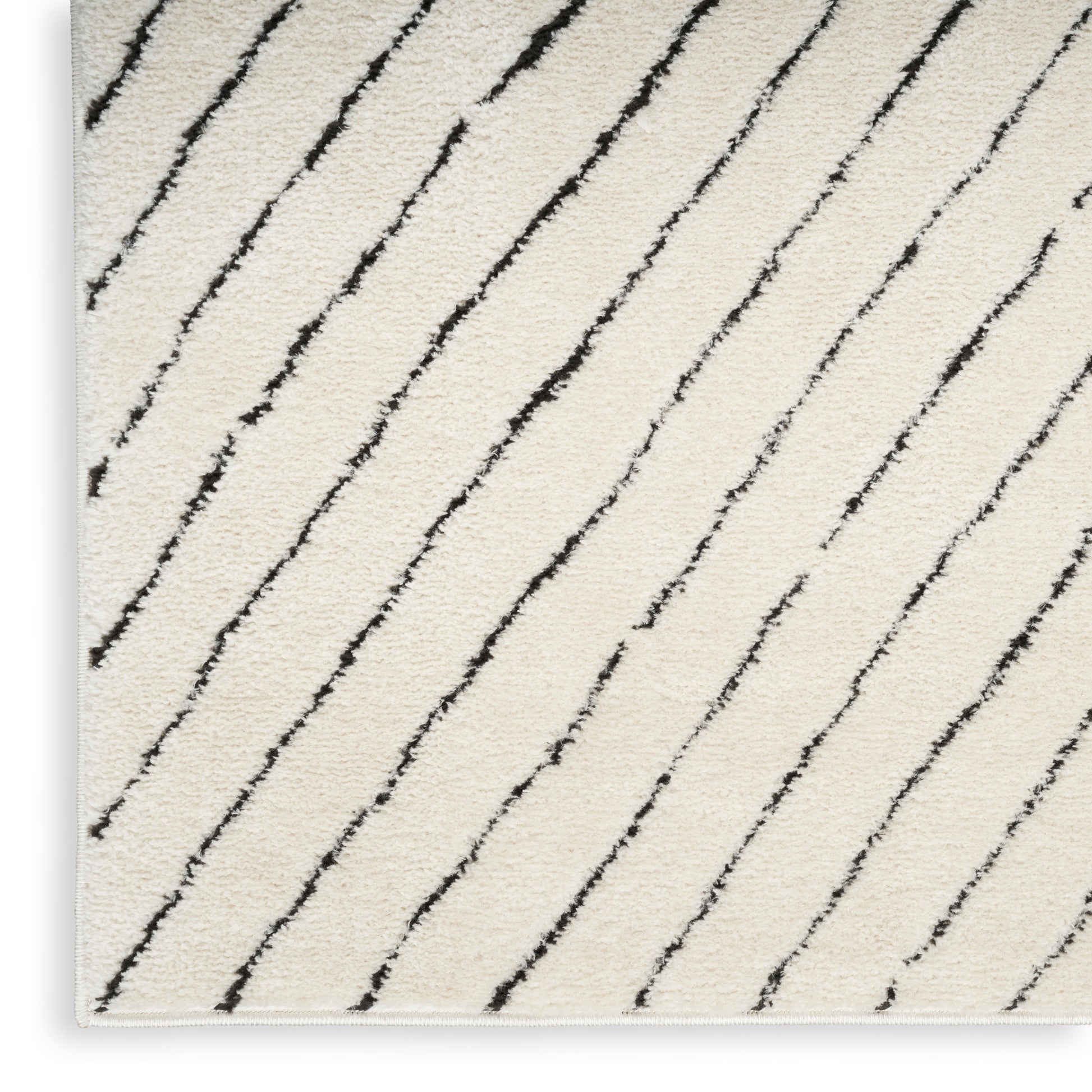 Cream area rug with black diagonal stripes and plush texture, modern design.