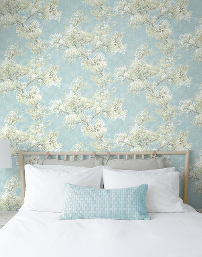 Blue floral peel and stick wallpaper featuring graceful cherry blossom branches, soft green foliage, and a serene garden-inspired pattern. Cherry Blossom Grove wallpaper in Blue Mist and Green Tea adds a fresh botanical look to accent walls, bedrooms, nurseries, living rooms, and modern cottage-style interiors. Easy-to-install removable wallpaper ideal for renters and home makeovers.