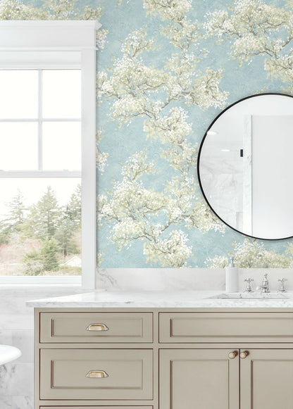 Blue floral peel and stick wallpaper featuring graceful cherry blossom branches, soft green foliage, and a serene garden-inspired pattern. Cherry Blossom Grove wallpaper in Blue Mist and Green Tea adds a fresh botanical look to accent walls, bedrooms, nurseries, living rooms, and modern cottage-style interiors. Easy-to-install removable wallpaper ideal for renters and home makeovers.