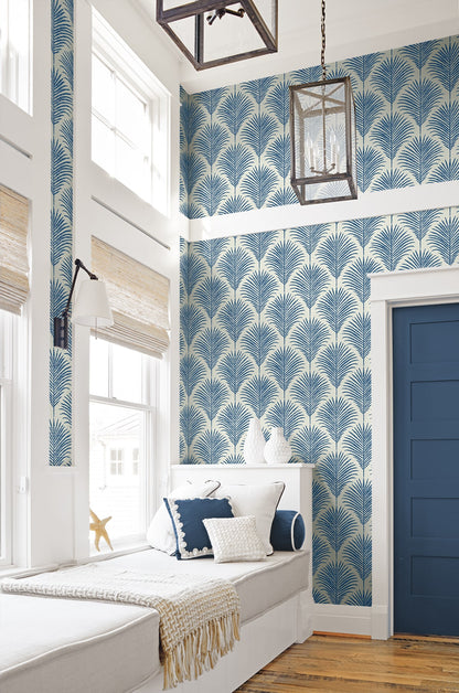 Coastal blue palm peel and stick wallpaper featuring tropical botanical leaves, removable wallcovering for beach house decor, accent walls, and modern coastal interior design.