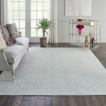 Rectangular light blue area rug with subtle ivory floral pattern in a chic living room.