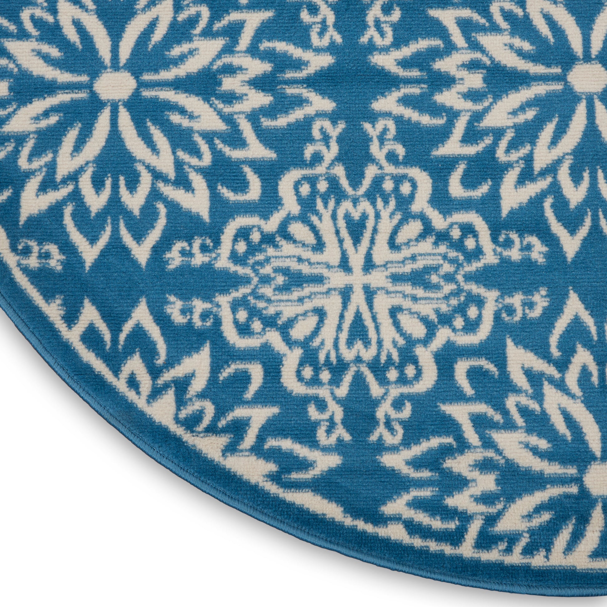 Round teal rug with white Nordic snowflake pattern and blue edge.