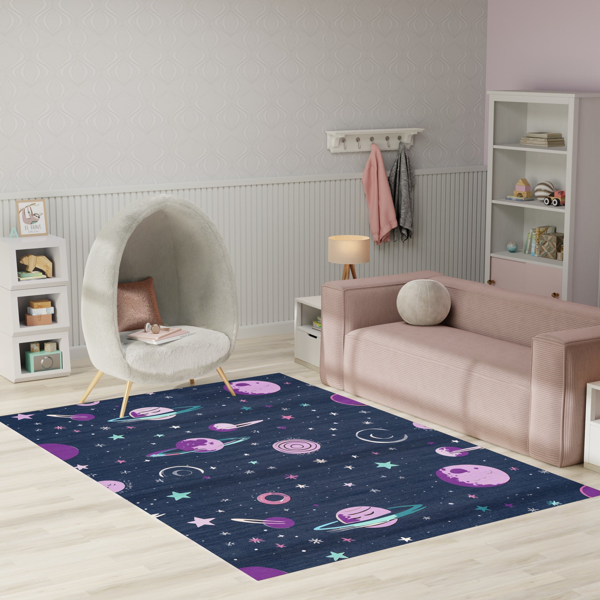 Space-themed navy rug with pink planets and stars in a kids' playroom, pastel pink sofa and white egg chair.