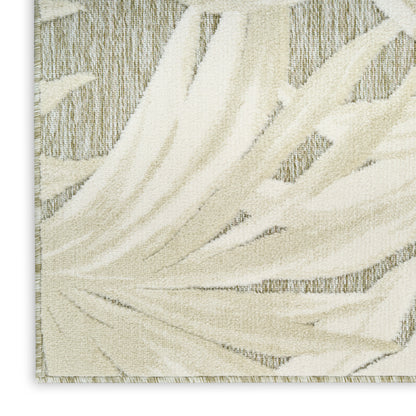 Cream-beige palm-leaf patterned rug with textured pile and light border, modern decorative floor mat.