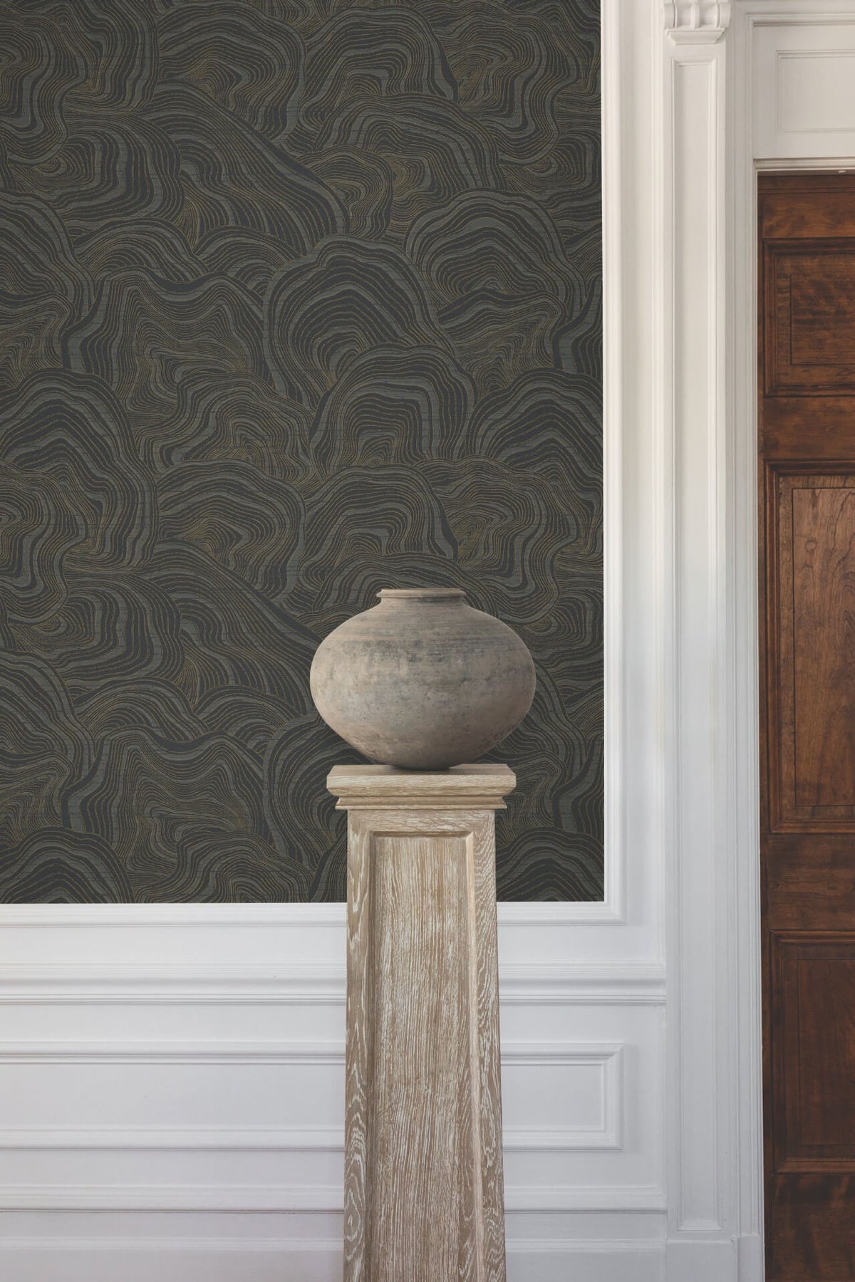 Luxury black wallpaper featuring a repeating pattern of layered geode shapes outlined and accented with rose gold metallic. The reflective mineral-inspired details add warmth, glamour and visual dimension to bedrooms, dining rooms, living spaces and accent walls.
