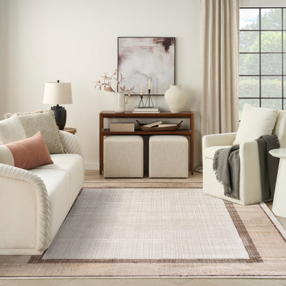 Neutral living room with cream sofa, blush pillow, dark wood console, beige ottomans, abstract art, vase & candles.