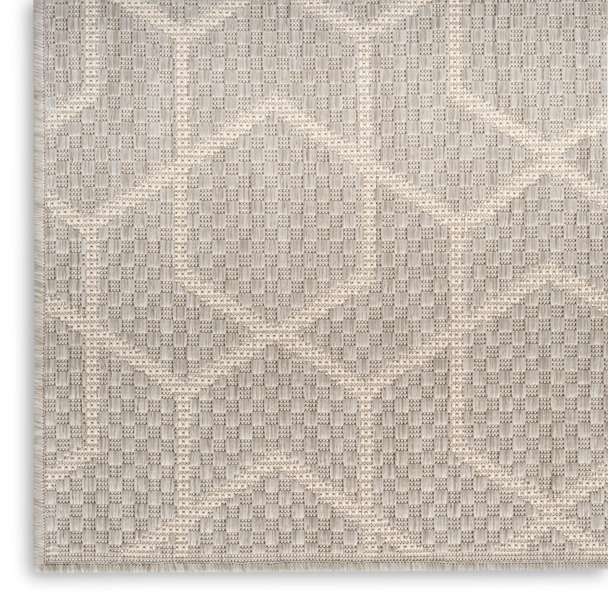 Beige woven rug with geometric diamond pattern, textured surface and neutral warm tones.