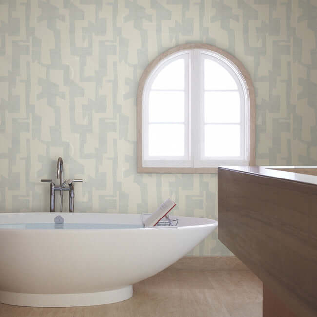 Modern Tribal wallpaper by Nikki Chu featuring a soft grey textured background with bold geometric tribal patterns in steel-blue tones. A contemporary non-woven wallcovering designed for modern interiors, accent walls, bedrooms, living rooms, and office spaces with a stylish artistic and textured finish.