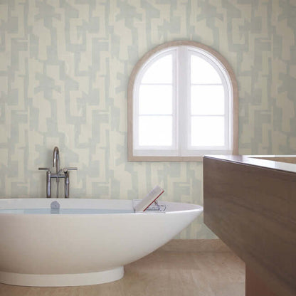 Modern Tribal wallpaper by Nikki Chu featuring a soft grey textured background with bold geometric tribal patterns in steel-blue tones. A contemporary non-woven wallcovering designed for modern interiors, accent walls, bedrooms, living rooms, and office spaces with a stylish artistic and textured finish.