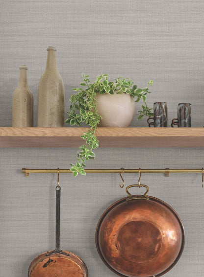 Washed Linen Gravel wallpaper featuring a subtle grey linen-inspired texture with soft horizontal striping that creates a natural woven fabric effect. A minimalist neutral wallcovering ideal for modern, Scandinavian, farmhouse, and transitional interior design spaces such as bedrooms, living rooms, offices, and accent walls.