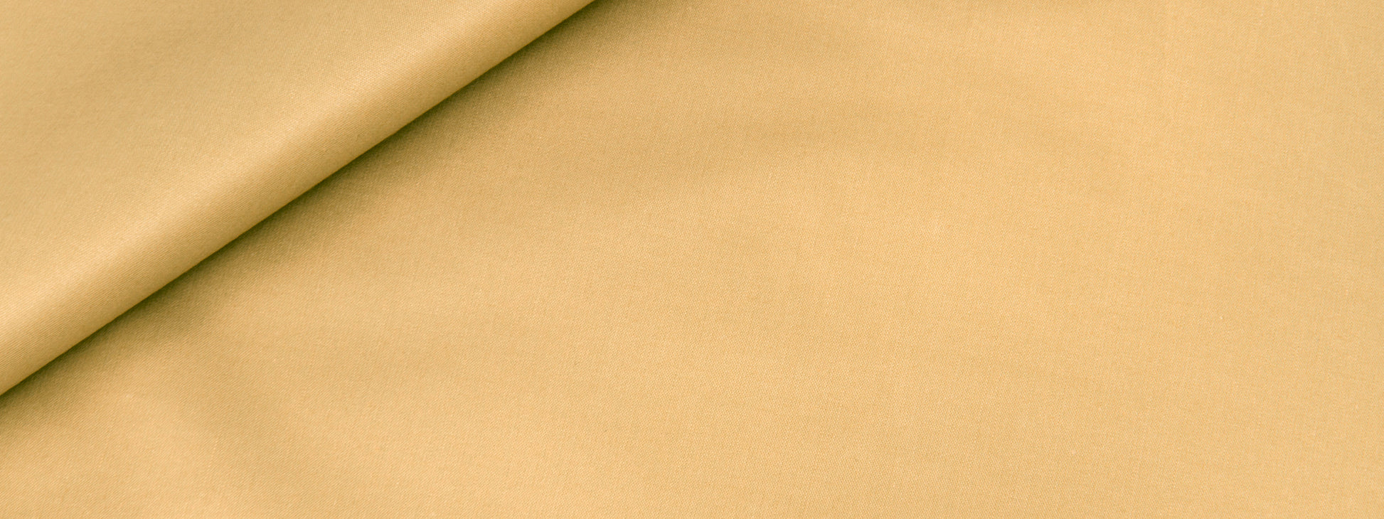 Beige fabric with a rolled edge and soft diagonal fold; smooth warm-toned textile.
