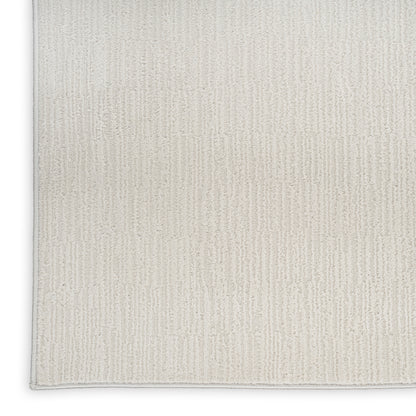 Beige rectangular rug with soft woven texture and subtle vertical rib pattern, light gray edge binding.
